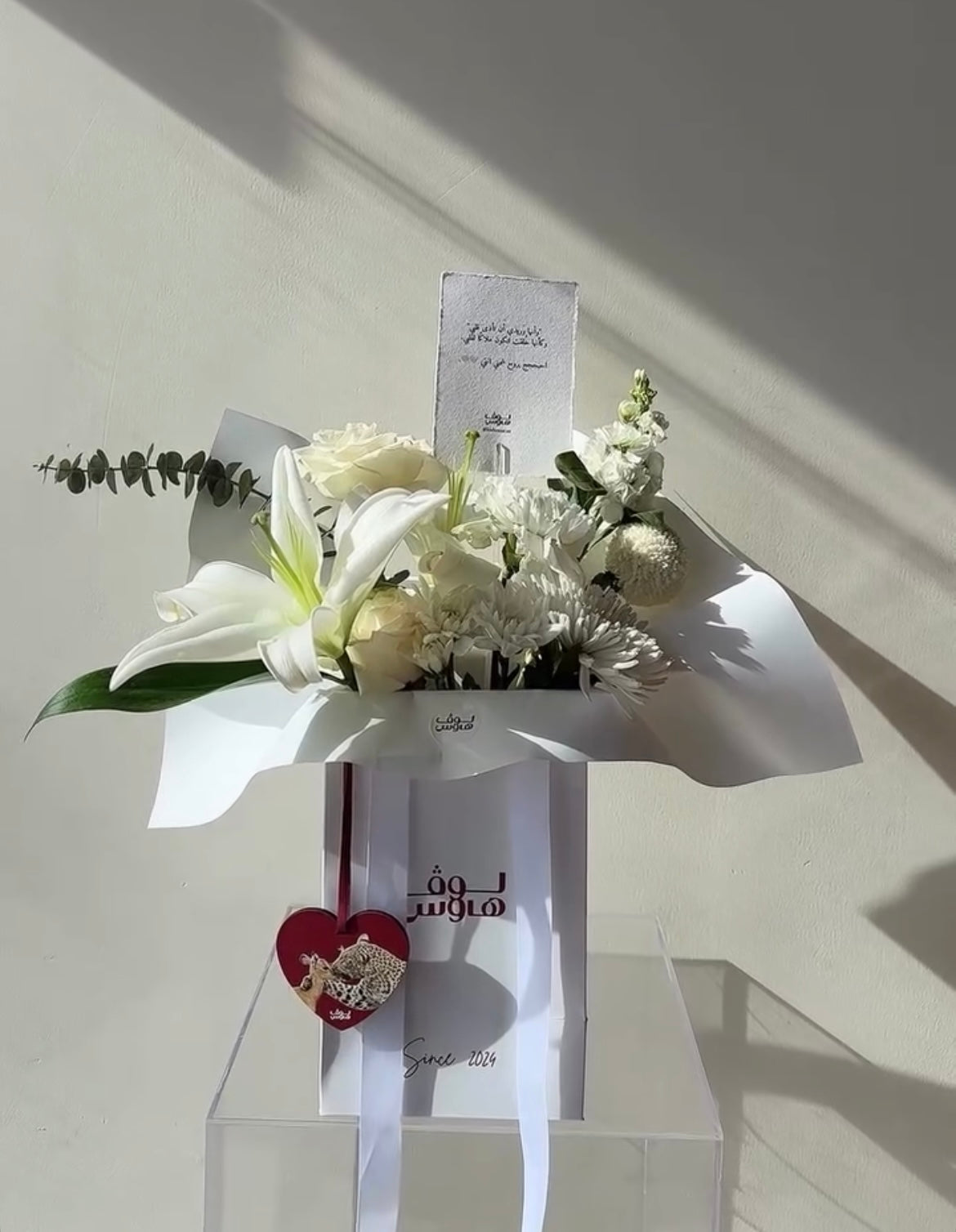 تنسيق ورد أبيض مع ميدالية قلب حمراء