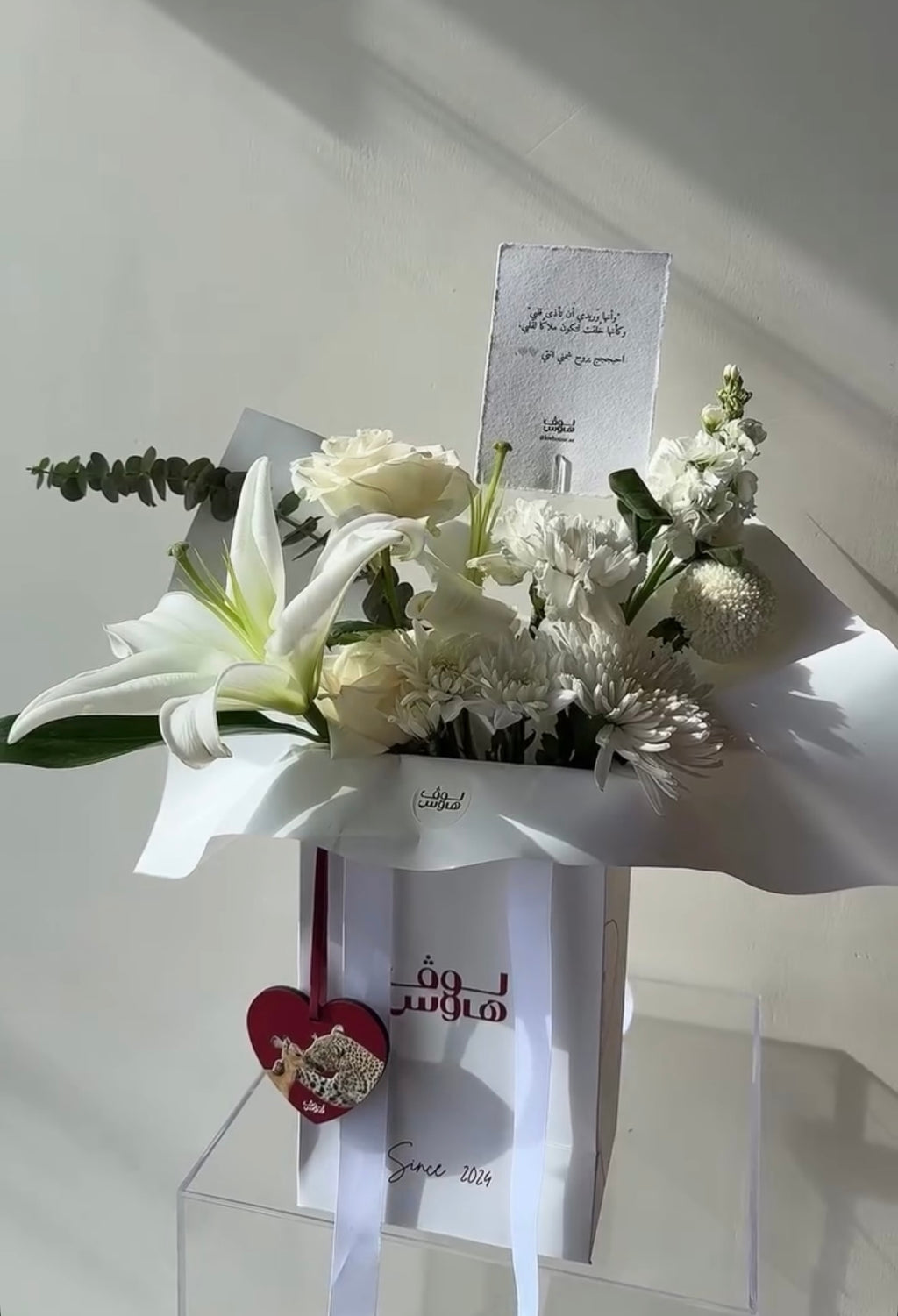 تنسيق ورد أبيض مع ميدالية قلب حمراء
