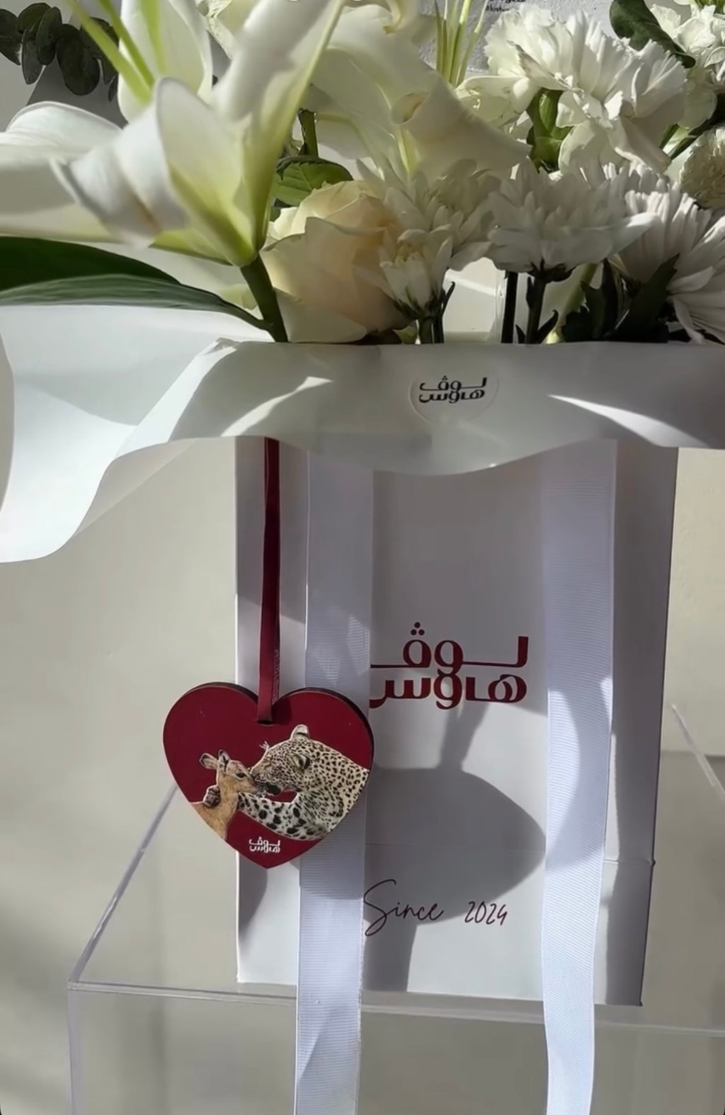 تنسيق ورد أبيض مع ميدالية قلب حمراء