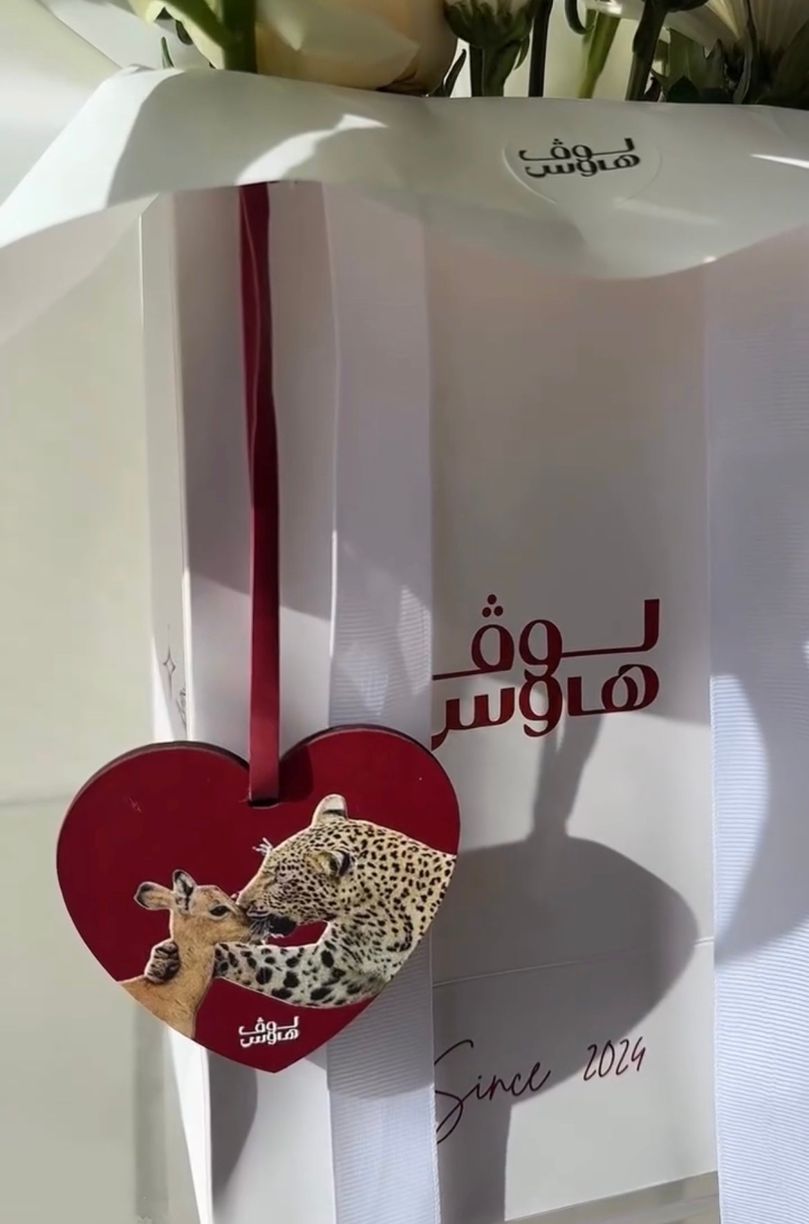 تنسيق ورد أبيض مع ميدالية قلب حمراء