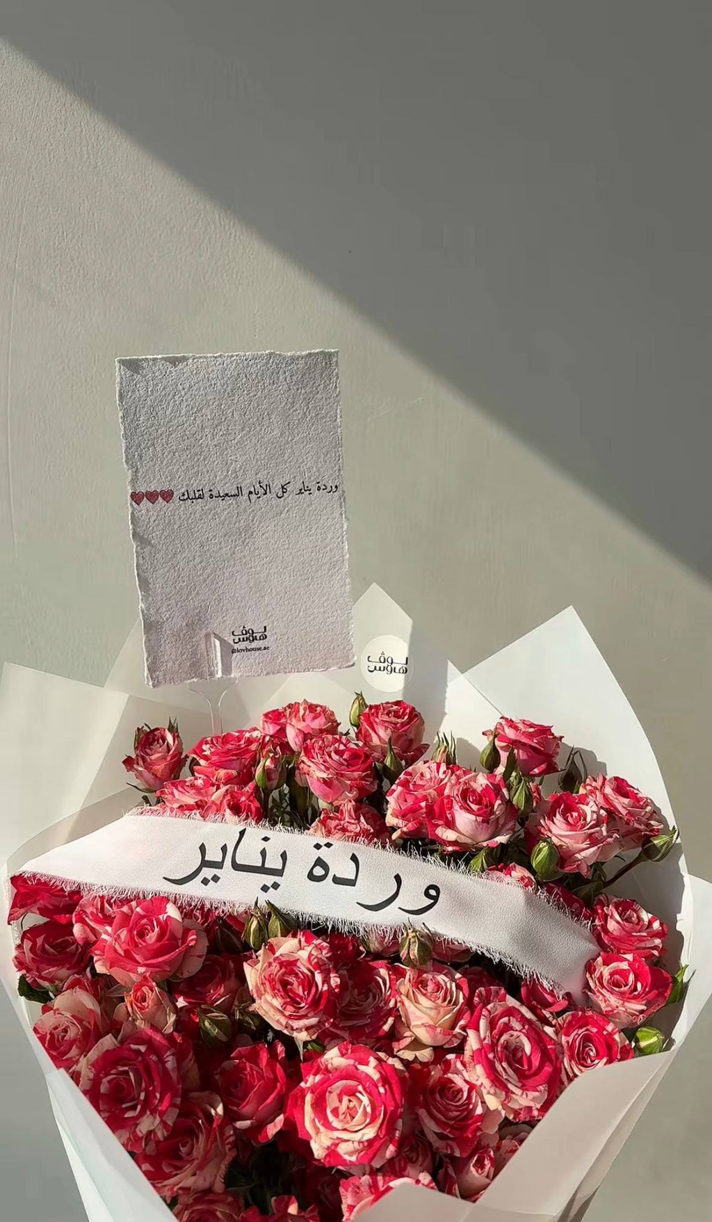 باقة وردية مع شريطة وردة الشهر