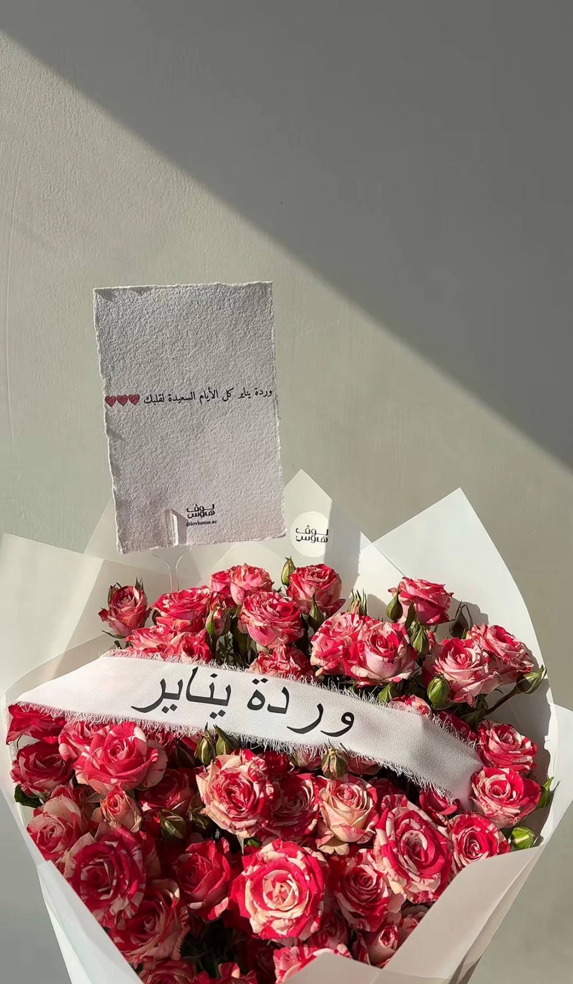 باقة وردية مع شريطة وردة الشهر