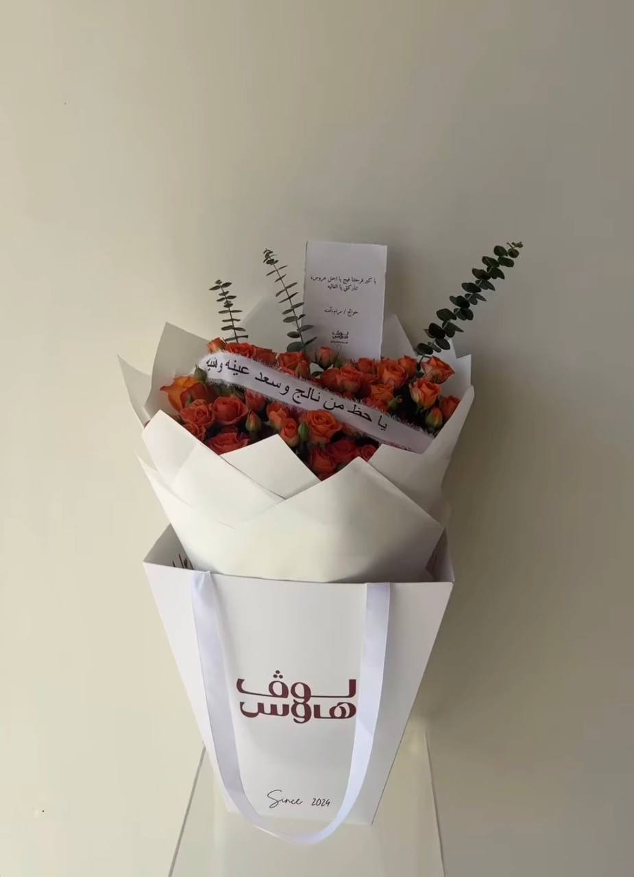 باقة برتقالية مع شريطة يا حظ من نالج